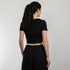 Rave Girl mit schwarzem Techno Crop Top mit "Decay" Motiv, fotografiert von hinten